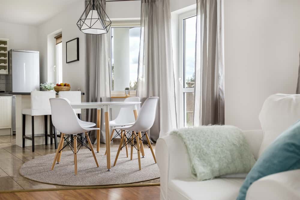 New flat with round table, white chairs and open kitchen