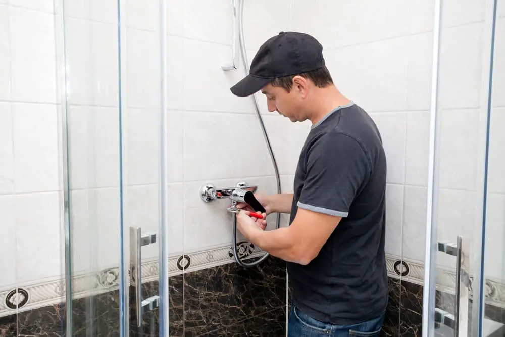 man fixing a shower faucet